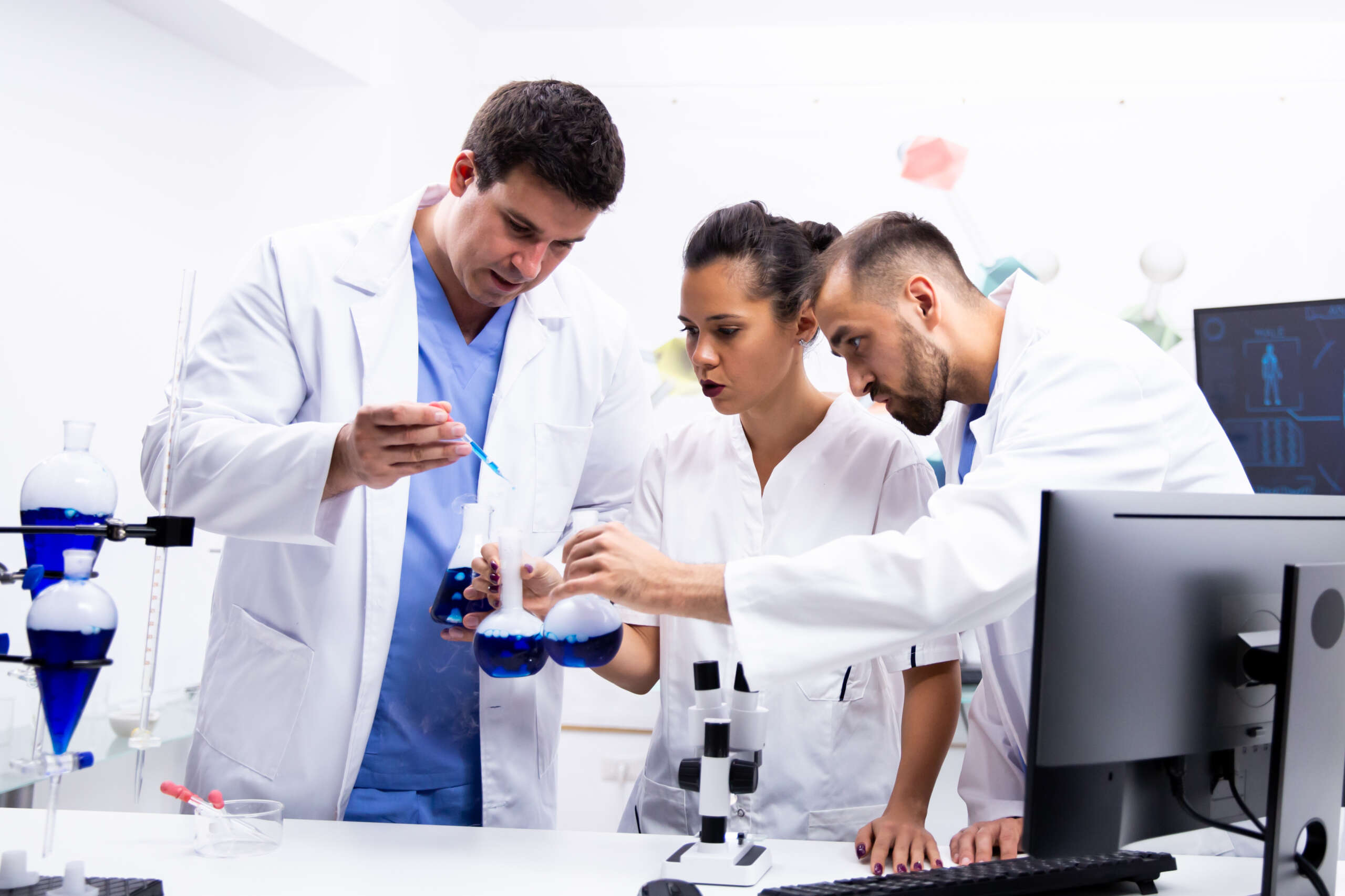 team of scientist in white coat working together with smoking blue liquid